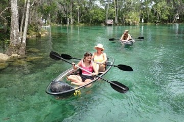 a group of people riding on the back of a boat in the water